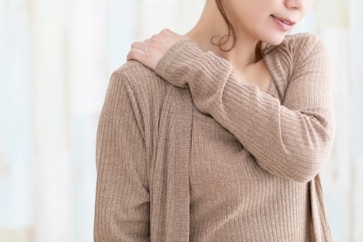 肩を抑える女性
